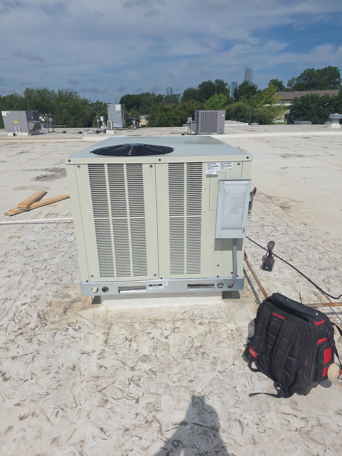 Newly installed commercial rooftop AC unit with Austin skyline