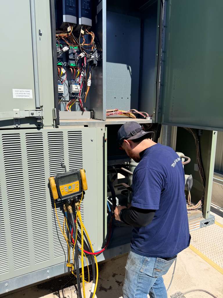 Technician running diagnostics on large commercial HVAC unit