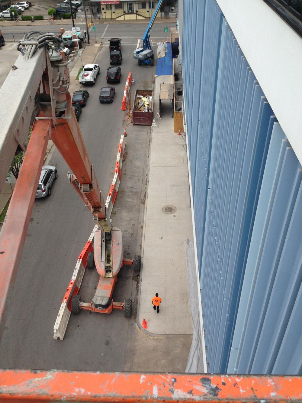 View from a boom lift down to the street while repainting a commercial building