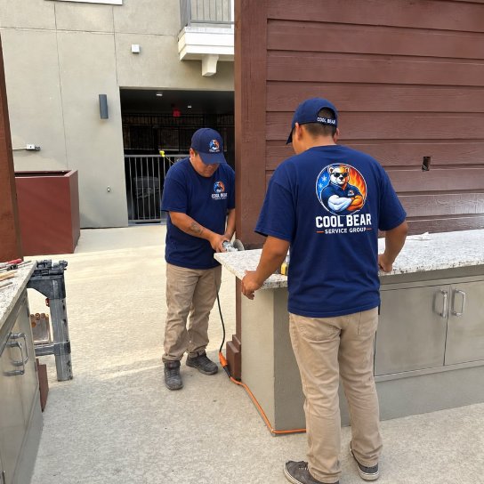 Cool Bear team member cutting a granite countertop for the poolside grill area